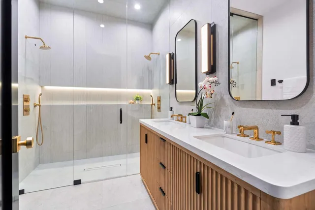 a bathroom with a double vanity sink toilet mirror and bathtub