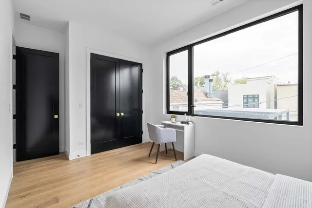 a bedroom with a bed and wooden floor