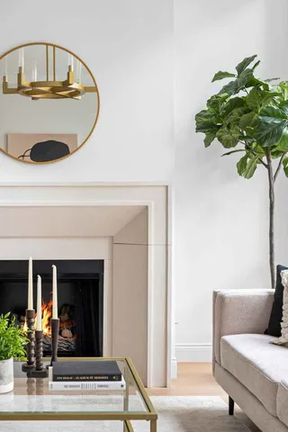 a living room with furniture a fireplace and a large window