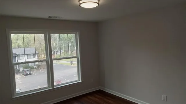 a view of an empty room with wooden floor