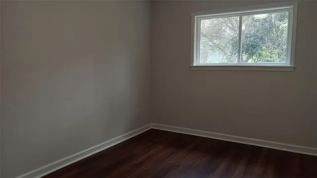 a view of a small space with wooden floor and windows