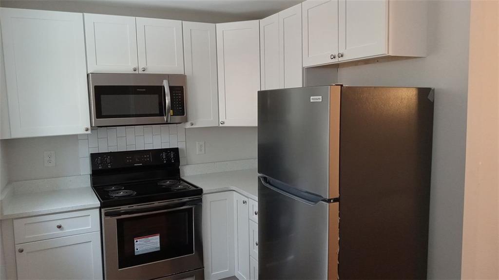 2156 Park Terrace, Unit 3 Atlanta, GA 30337 - Photo 10 of 29 a kitchen with stainless steel appliances white cabinets and a refrigerator