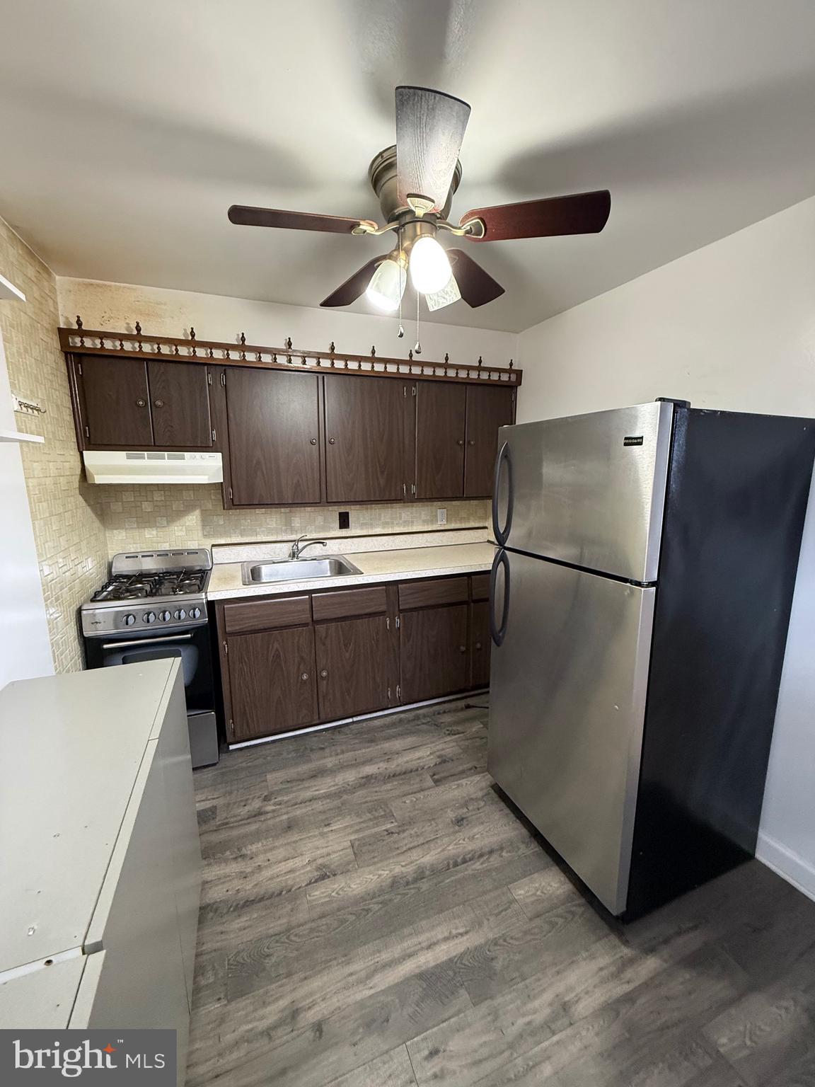 3220 Guilford Street Philadelphia, PA 19136 - Photo 13 of 20 a kitchen with stainless steel appliances a sink cabinets and a wooden floor