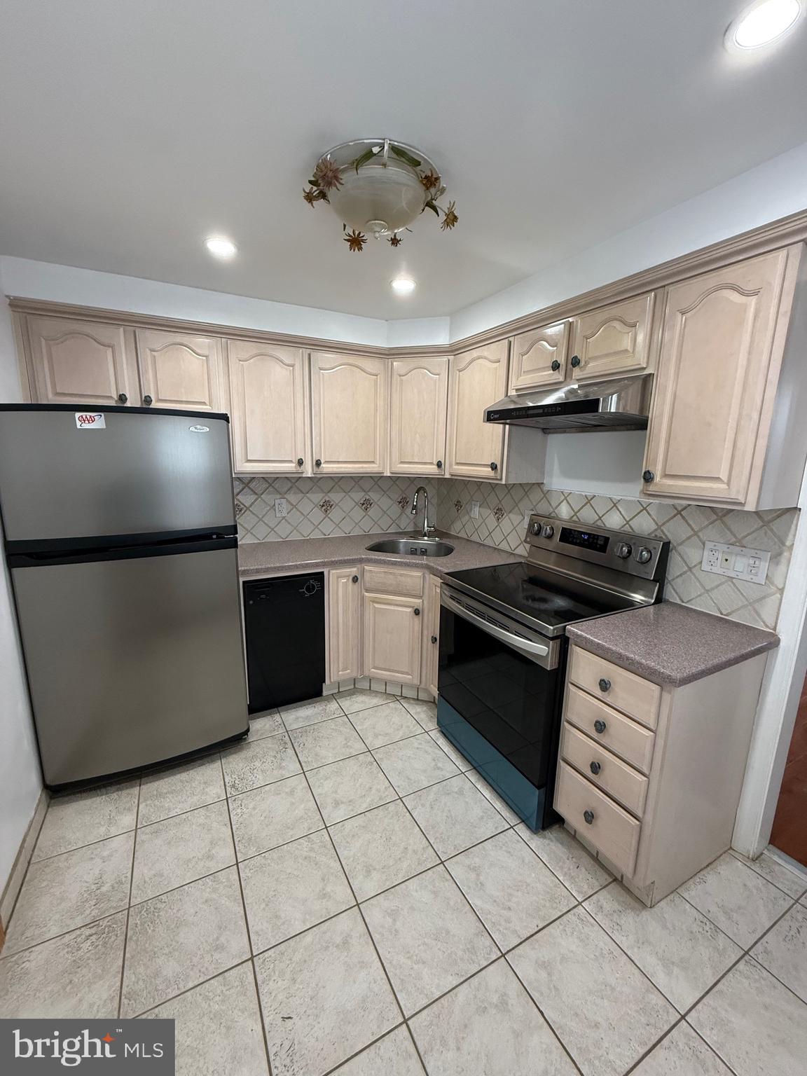 3220 Guilford Street Philadelphia, PA 19136 - Photo 5 of 20 a kitchen with stainless steel appliances granite countertop a sink and a refrigerator