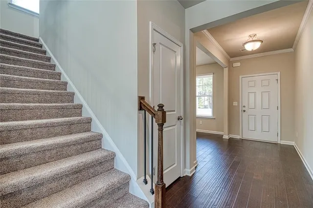 a view of a hallway with wooden floor and stairs