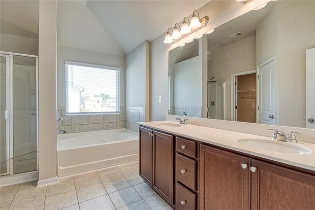 a bathroom with a sink double vanity granite tub and a mirror
