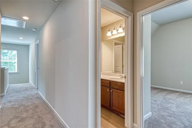 a view of a hallway and a livingroom with a bathroom