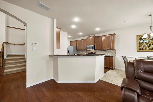 a view of kitchen with granite countertop cabinets and refrigerator
