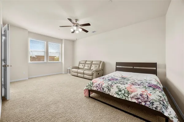 a living room with furniture and a ceiling fan