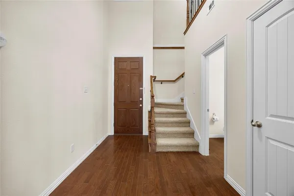 a view of a hallway with wooden floor and entryway