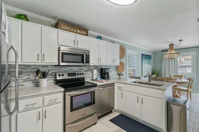 a kitchen with white cabinets stainless steel appliances and sink