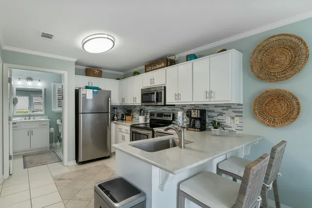 a kitchen with stainless steel appliances granite countertop a sink refrigerator stove and microwave