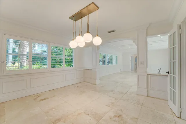 a large kitchen with granite countertop a sink and white cabinets