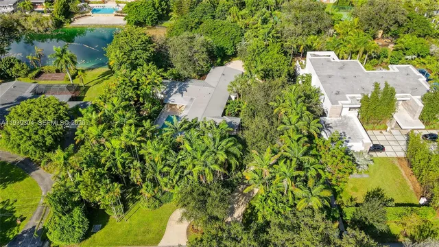 an aerial view of residential house with outdoor space and trees all around