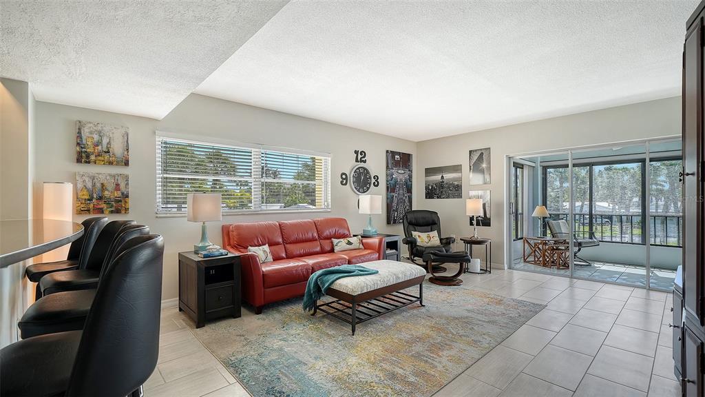 225 Hour Glass Way, Unit 202 Sarasota, FL 34242 - Photo 12 of 68 a living room with furniture and a floor to ceiling window