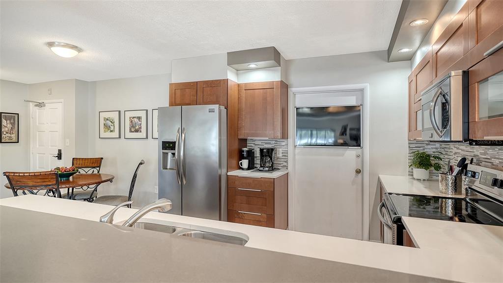 225 Hour Glass Way, Unit 202 Sarasota, FL 34242 - Photo 25 of 68 a kitchen with stainless steel appliances refrigerator stove microwave and cabinets