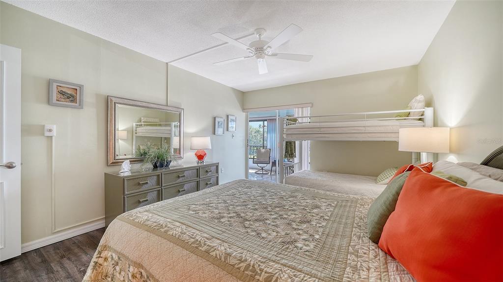 225 Hour Glass Way, Unit 202 Sarasota, FL 34242 - Photo 29 of 68 a bedroom with a large bed and a chandelier