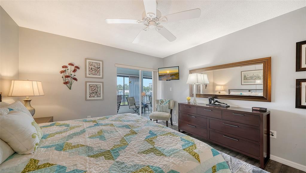 225 Hour Glass Way, Unit 202 Sarasota, FL 34242 - Photo 32 of 68 a bedroom with a bed and wooden floor