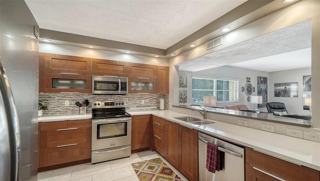 225 Hour Glass Way, Unit 202 Sarasota, FL 34242 - Photo 8 of 68 a kitchen with stainless steel appliances granite countertop a sink and stove