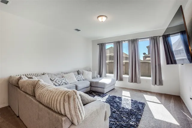 a living room with furniture and large windows