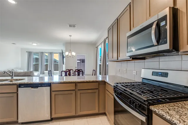 a kitchen with stainless steel appliances granite countertop a sink stove and microwave