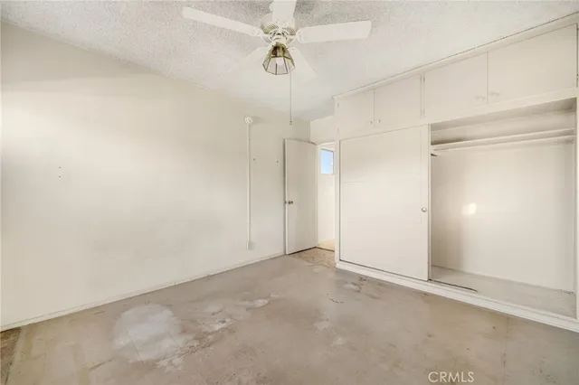 an empty room with a ceiling fan and painted walls