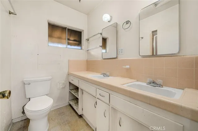 a bathroom with a toilet sink a mirror and vanity