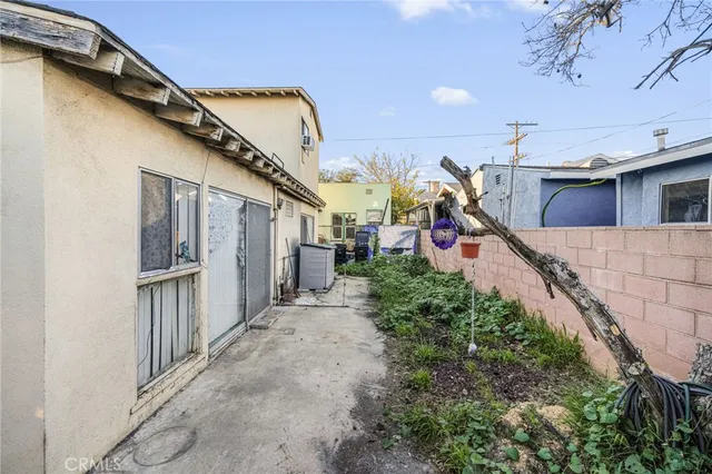 a view of a house with a small yard and potted plants
