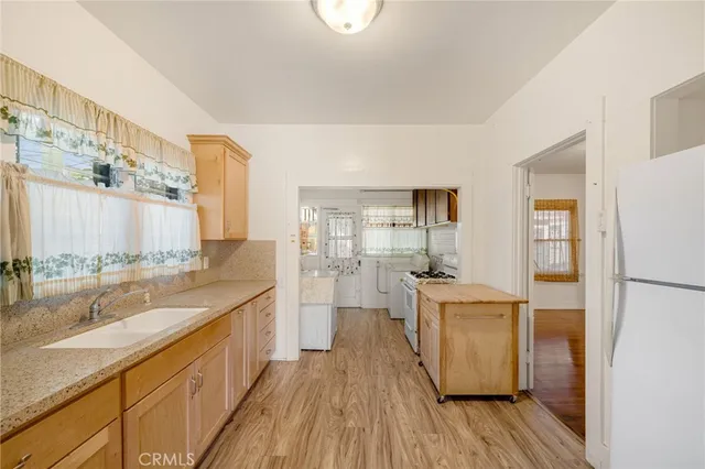 a large kitchen with a lot of counter space and wooden floor