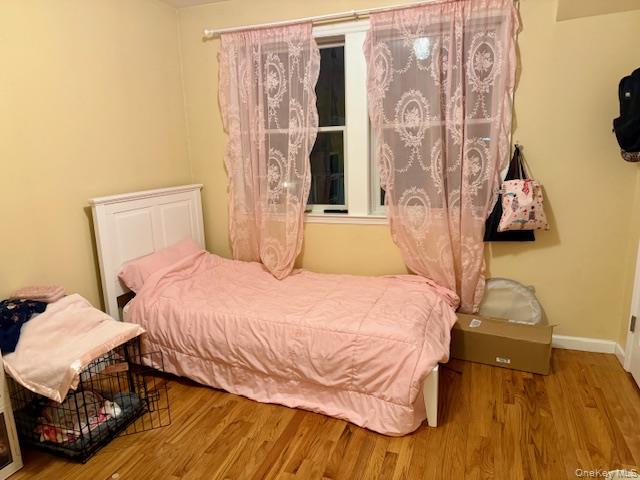 120 East 6th Road Queens, NY 11693 - Photo 5 of 20 a bedroom with a bed and wooden floor