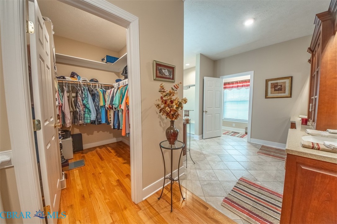 120 North Shore Road Locust Hill, VA 23092 - Photo 19 of 39 Full bathroom featuring a spacious closet, vanity, and light wood-type flooring