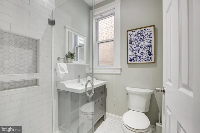 a bathroom with a toilet sink and mirror