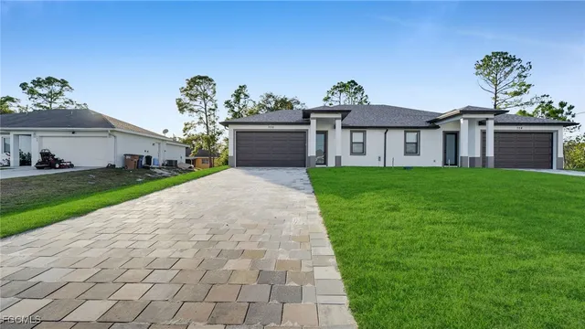 a front view of a house with a yard and potted plants