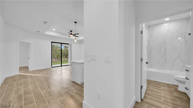 an empty room with windows and fan