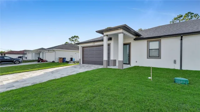 a front view of a house with a yard and garage