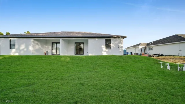 a front view of a house with a yard and trees