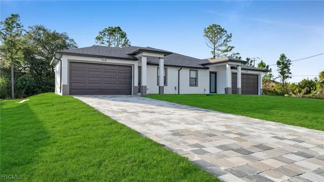a front view of a house with a yard and garage