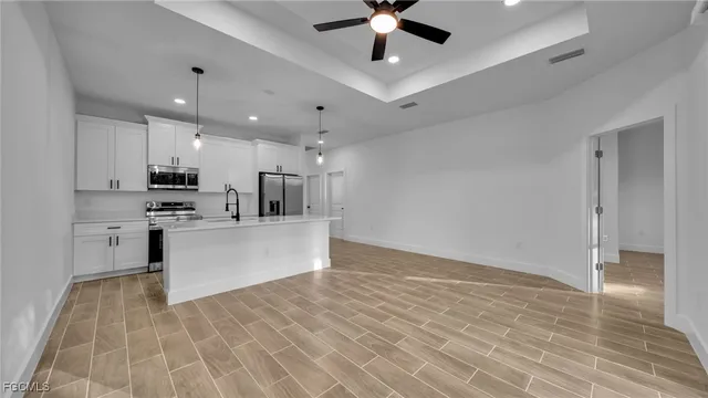 a view of kitchen with stainless steel appliances refrigerator stove microwave and cabinets