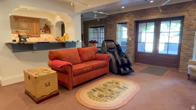 426 West Center Street Parowan, UT 84761 - Photo 62 of 107 Lower-level entertainment space featuring a wet bar with wood cabinetry and tile backsplash, double glass-paneled doors, stone accent wall, and recessed lighting
