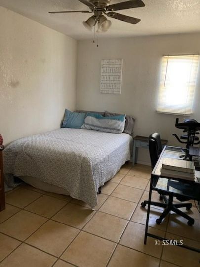 232 North Alvord Street Ridgecrest, CA 93555 - Photo 5 of 11 a bedroom with a bed and a chandelier