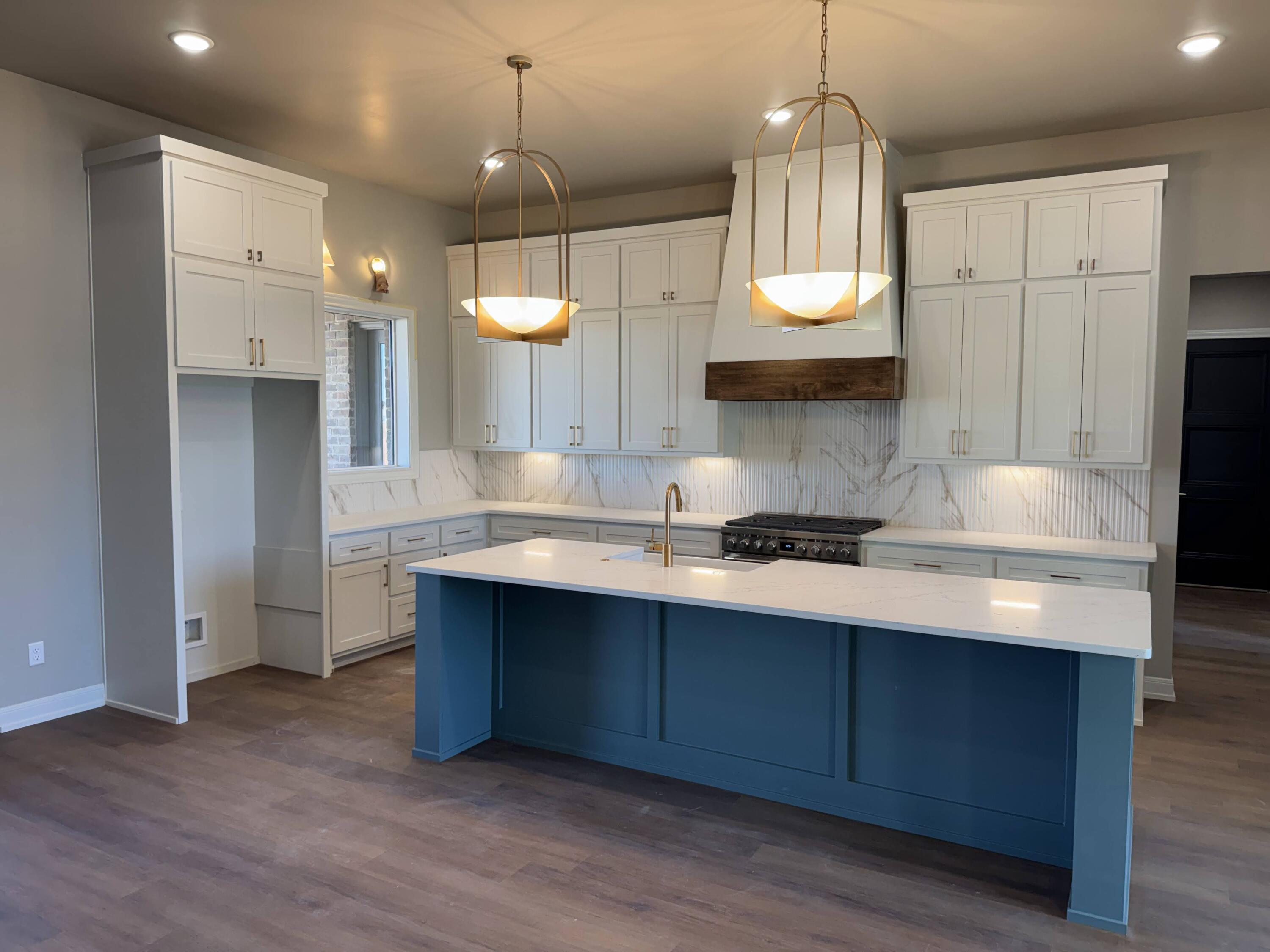 309 Maple New Home, TX 79381 - Photo 4 of 27 a kitchen with stainless steel appliances a sink stove and wooden floor