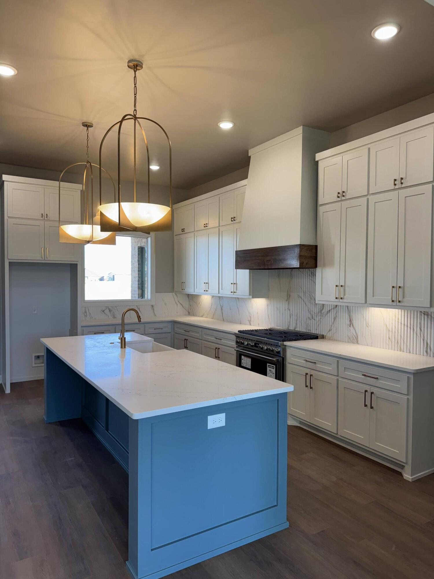 309 Maple New Home, TX 79381 - Photo 6 of 27 a kitchen with stainless steel appliances granite countertop a sink a stove and a wooden floors