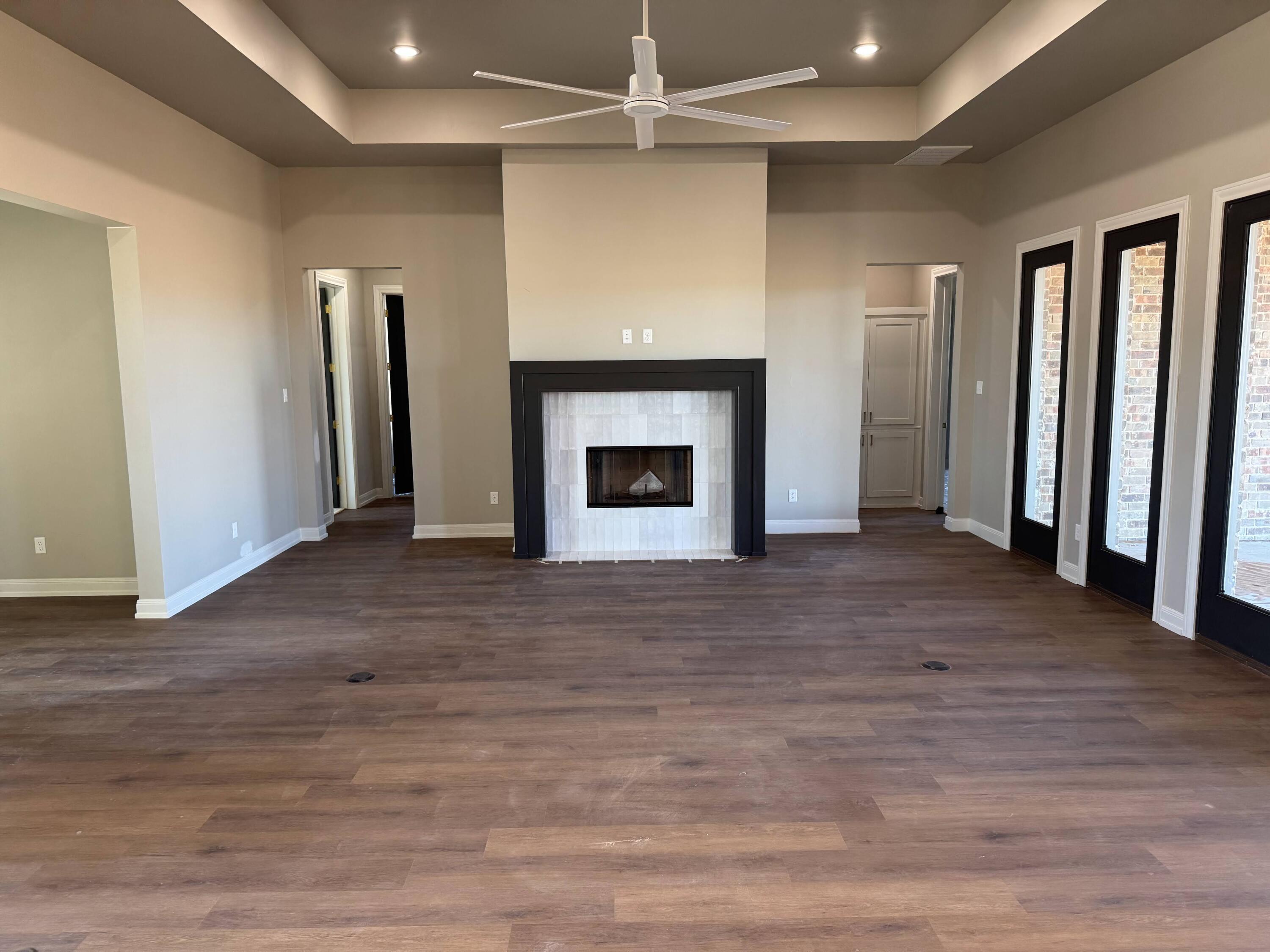309 Maple New Home, TX 79381 - Photo 7 of 27 an empty room with wooden floor fireplace and windows
