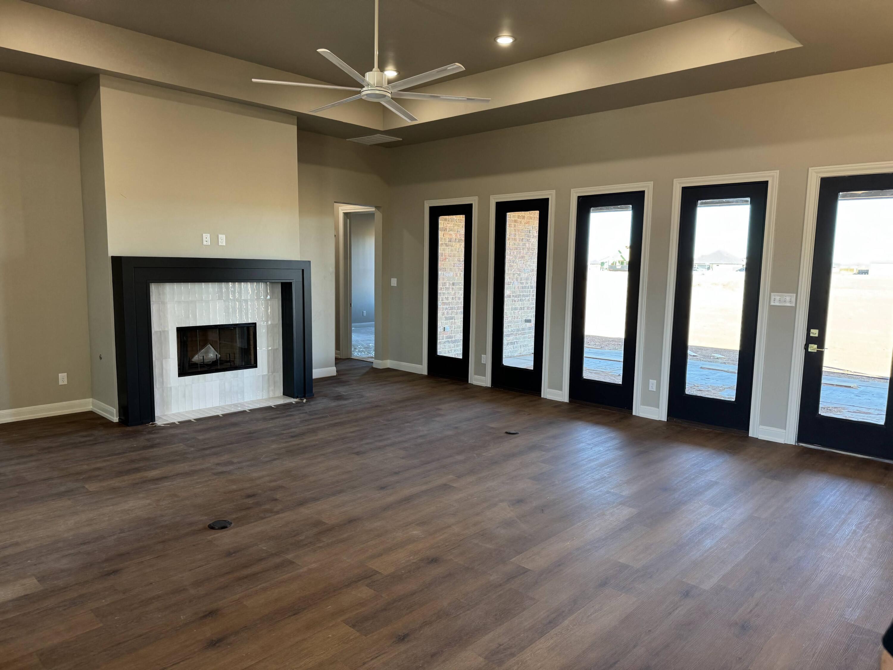 309 Maple New Home, TX 79381 - Photo 8 of 27 an empty room with wooden floor fireplace and windows