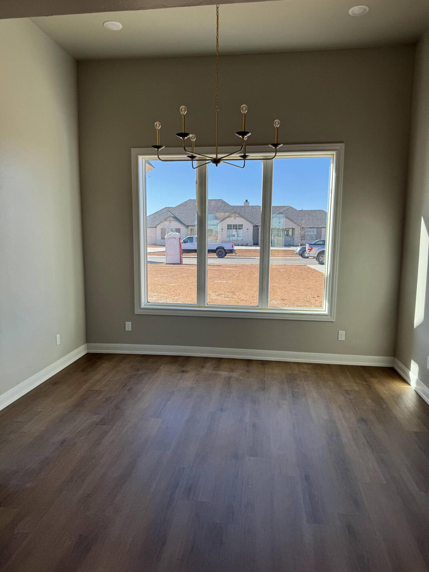 309 Maple New Home, TX 79381 - Photo 10 of 27 an empty room with wooden floor and windows