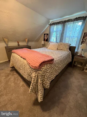a bed sitting in a bedroom next to a window
