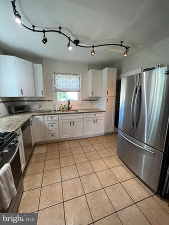 a kitchen with stainless steel appliances granite countertop a refrigerator sink and cabinets