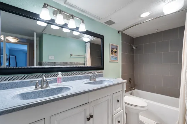a bathroom with a granite countertop sink a toilet and a mirror