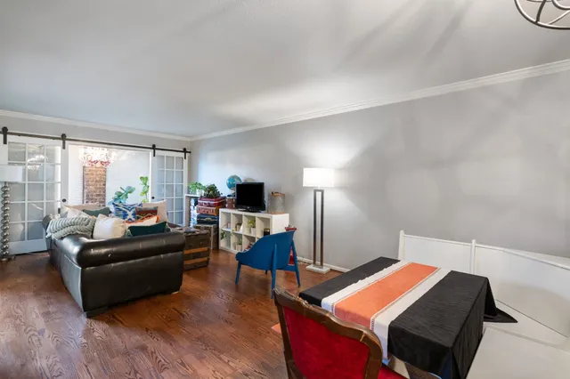 a living room with furniture a flat screen tv and a large window