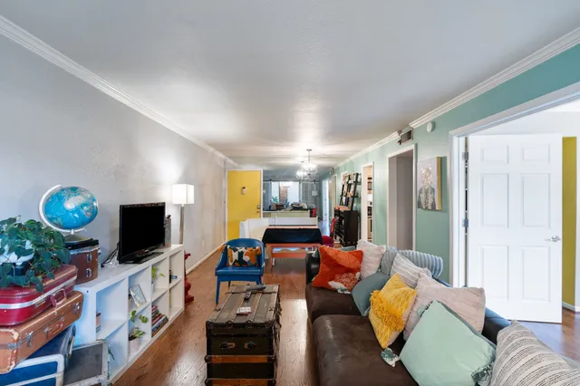 a living room with furniture a flat screen tv and a floor to ceiling window